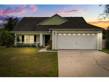 Charming single-story home with a well-maintained lawn and attached two-car garage, set against a colorful twilight sky at 3304 Kelsey Ln, St Cloud, FL 34772