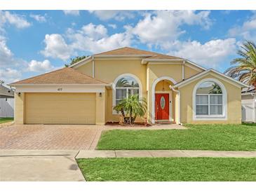Inviting single-story home with a vibrant red front door, arched windows, and well-maintained landscaping at 477 Bohannon Blvd, Orlando, FL 32824