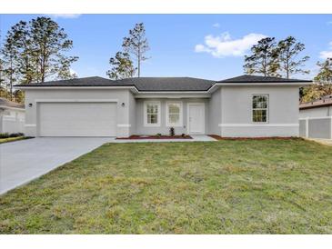 Charming single-story home with a well-manicured lawn, attached garage, and neutral-colored exterior at 773 Marion Oaks Pass, Ocala, FL 34473
