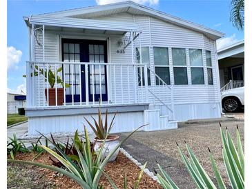 Charming single-story home with blue front door, white railings, and lush landscaping at 9000 Us Highway 192 # 835, Clermont, FL 34714