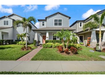 Charming two-story home with a landscaped yard, walkway, and a welcoming covered front porch at 12064 Encore At Ovation Way, Winter Garden, FL 34787