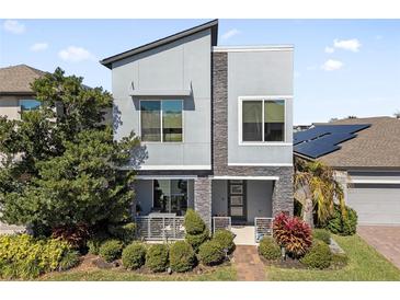 Stunning contemporary two-story home with stone accents, manicured landscaping and solar panels at 1763 Standing Rock Cir, Oakland, FL 34787