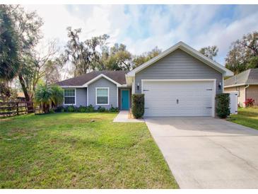 Charming single-story home with a well-manicured lawn and a two-car garage at 377 Columbus Ave, Orange City, FL 32763