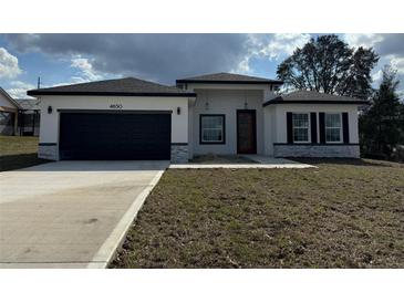 Beautiful single-story home with a two-car garage, modern design, and well-manicured lawn at 4650 Sw 139Th Pl, Ocala, FL 34473