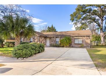 Charming single story home with stone facade, mature trees, and a spacious driveway at 6209 Beaumont Ave, Orlando, FL 32808