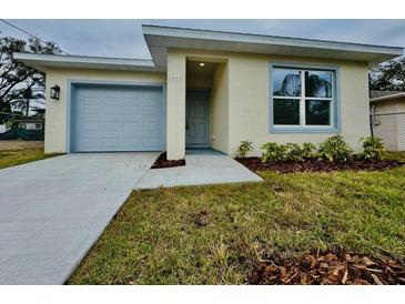 Charming single-story home featuring a one car garage, well-maintained lawn, and freshly landscaped flower beds at 1007 Colyer St, Orlando, FL 32805