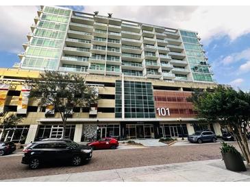 Modern high-rise condo building with large windows, multiple balconies and street level retail at 101 S Eola Dr # 921, Orlando, FL 32801