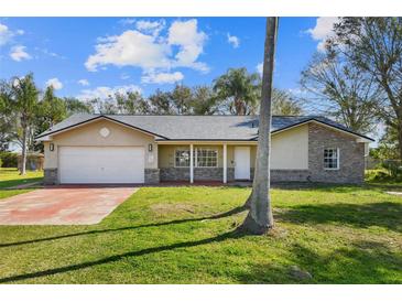 Charming single-story home with brick accents, well-maintained lawn, and attached two-car garage at 1157 Schooner Dr, Kissimmee, FL 34744