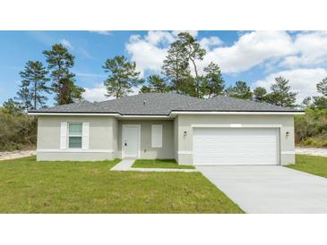 Charming single-story home with a two-car garage, well-manicured lawn, and a welcoming front entrance at 13283 Sw 30Th Terrace Rd, Ocala, FL 34473