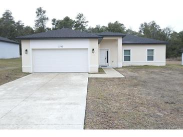 Charming single-Gathering home featuring a two-car garage, neutral stucco siding, and a well-maintained front yard at 13745 Sw 43Rd Cir, Ocala, FL 34473