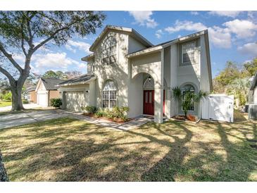 Two-story home featuring an arched entryway, lush landscaping, and a well-maintained lawn, exuding charm and curb appeal at 1428 Oberlin Ter, Lake Mary, FL 32746