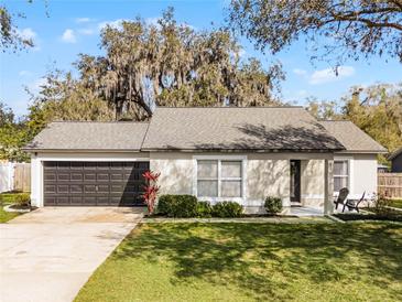 Charming single-story home featuring a well-maintained lawn and a two-car garage at 52 Bay Ridge Loop, Mascotte, FL 34753