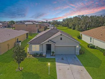 Charming single-story home featuring a well-manicured lawn, attached garage, and inviting front entrance at 5590 Forest Ridge Dr, Winter Haven, FL 33881