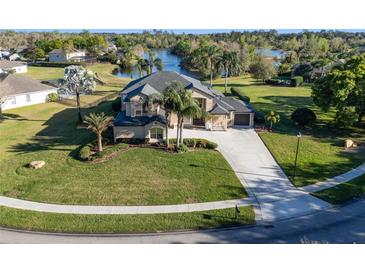 Stunning home with lush landscaping, a long driveway, and a serene lake view in the background at 642 Osprey Lakes Cir, Chuluota, FL 32766