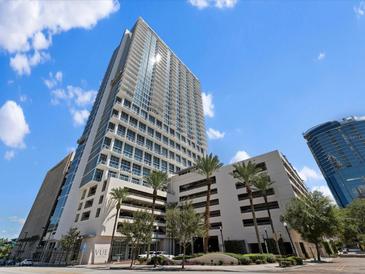 Beautiful high-rise building with a parking garage surrounded by well-maintained landscaping and palm trees at 150 E Robinson St # 1214, Orlando, FL 32801