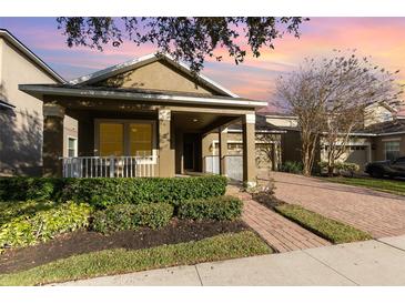 Home showcasing a cozy front porch, manicured landscaping, and a welcoming facade at 15174 Evergreen Oak, Winter Garden, FL 34787