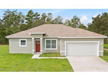 Charming single-story home features a well-manicured lawn, neutral paint, attached garage, and a red front door at 2531 Sw 167Th Loop, Ocala, FL 34473