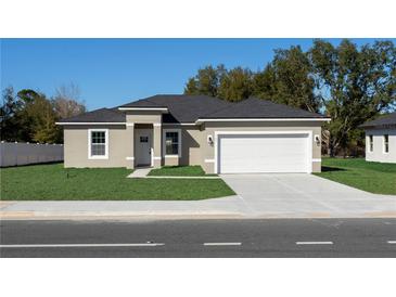 Charming single-story home with a well-manicured lawn and a two-car garage in a serene neighborhood at 325 Marion Oaks Trail, Ocala, FL 34473