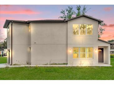 Two-story home with large windows providing ample natural light and a well-manicured lawn at 495 Dean Creek Ln, Orlando, FL 32825