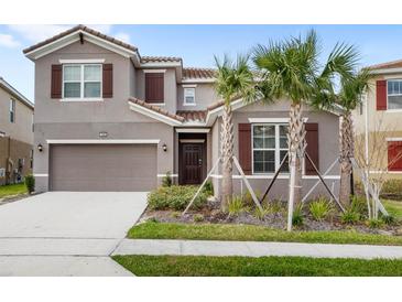Charming two-story home featuring a tile roof, brown shutters, and a well-maintained front yard with tropical landscaping at 7845 Oak Reflection Loop, Davenport, FL 33837