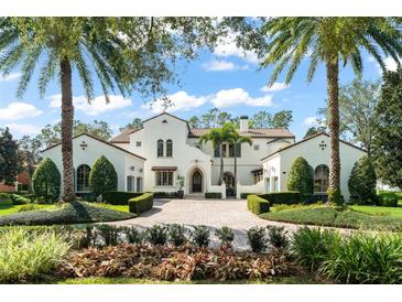 Stunning Mediterranean style home with lush landscaping, a circular driveway, and elegant architectural details at 11324 Bridge House Rd, Windermere, FL 34786