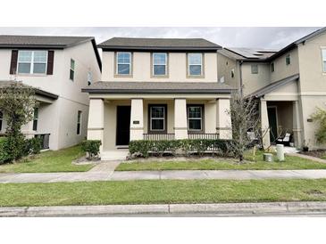 Inviting two-story home with manicured front lawn and charming porch at 12615 Salomon Cove, Windermere, FL 34786