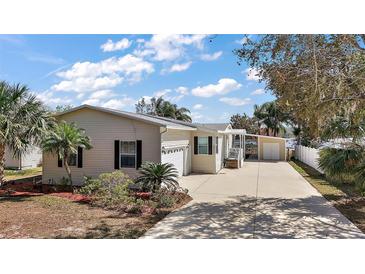 Charming single-story home with a long driveway, garage, and a separate carport offers ample parking at 13201 Plum Lake Cir, Minneola, FL 34715