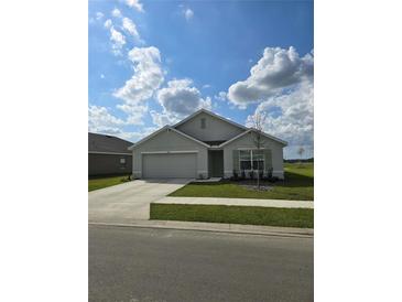 Charming one-story home with neutral exterior paint and manicured lawn at 3223 Evenmore Way, Wildwood, FL 34785