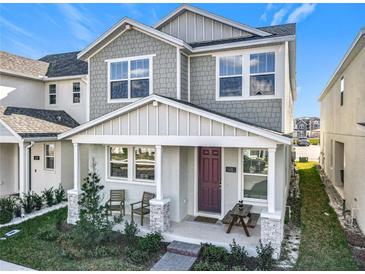 Charming two-story home with covered front porch, chairs, and nicely landscaped yard at 431 Scotsmans Pl, Debary, FL 32713