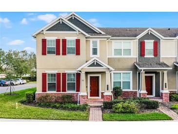 Charming two-story townhome featuring colorful shutters, brick accents, and well-maintained landscaping at 696 Orange Belt Loop, Winter Garden, FL 34787