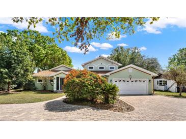 Charming home featuring a circular paver driveway and a lush, well-maintained front yard at 7496 Lake Marsha Dr, Orlando, FL 32819