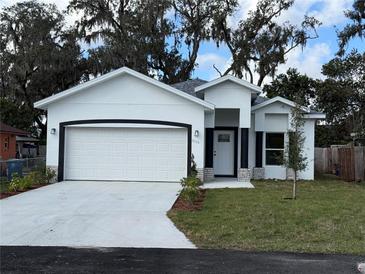 Charming single-story home featuring a well-manicured lawn and a two-car garage at 1006 India St, Haines City, FL 33844