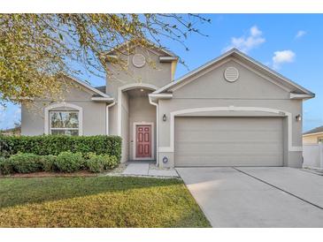 Charming single-Gathering home featuring a two-car garage, manicured lawn, and tasteful landscaping at 15506 Gemini Dr, Mascotte, FL 34753