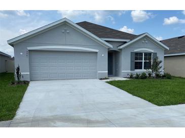 Charming single-story home with a two-car garage, a well-maintained lawn, and a neatly paved driveway at 4961 Sw 88Th Pl, Ocala, FL 34476