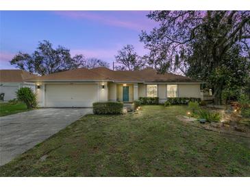 Charming single Gathering home featuring a well manicured lawn and garden with stone features under the light of dusk at 5149 Clarion Oaks Dr, Orlando, FL 32808