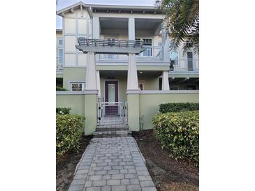 Inviting two-story condo with well-maintained landscaping, a private patio, and a modern pergola entry at 8266 Tavistock Lakes Blvd, Orlando, FL 32827