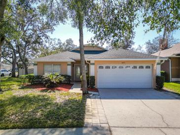 Charming single-story home featuring a two-car garage, well-maintained lawn, and mature trees at 4371 Weeping Willow Cir, Casselberry, FL 32707