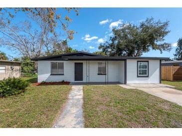 Charming single-story home with a well-manicured front yard and a gray concrete walkway leading to the front door at 913 Lake Ave, Edgewater, FL 32132