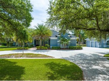 Beautiful single-story home with lush landscaping, palm trees and a spacious circular driveway at 1312 Winter Springs Blvd, Winter Springs, FL 32708