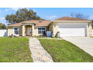 Charming home features a welcoming walkway and a well-maintained lawn at 600 Park Valley Cir, Minneola, FL 34715