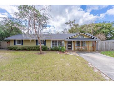 Charming single-story home features a well-maintained lawn, mature trees, and inviting front porch at 1361 Hobson St, Longwood, FL 32750