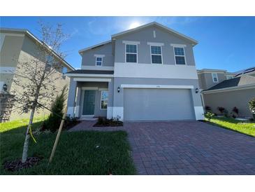 Two-story home featuring a brick driveway and a two-car garage at 1758 Tree Shade Dr, Davenport, FL 33837