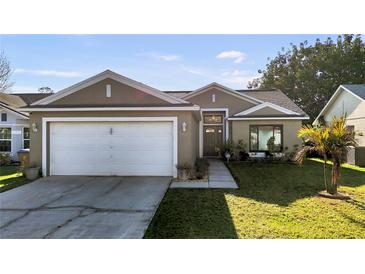 Charming one-story home with a well-manicured lawn and a two-car garage at 2417 Hybrid Dr, Kissimmee, FL 34758