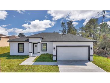 Charming single-story home with white stucco, black trim, and well-manicured lawn at 2844 Sw 162Nd Street Rd, Ocala, FL 34473