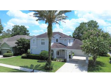 Two-story home with a well-manicured front lawn, circular windows and an attached carport at 2935 Willow Bay Ter, Casselberry, FL 32707