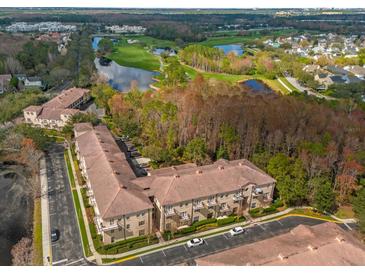 Aerial view of condos near a golf course, lakes, and mature trees at 706 Westpark Way # 203, Celebration, FL 34747