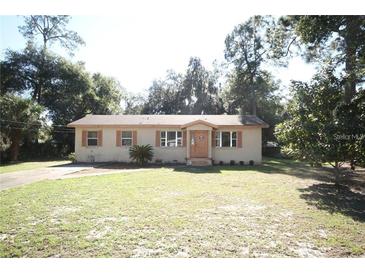 Charming single-story home features a well-maintained lawn and a classic front door with decorative shutters at 9 Lake Dr, Debary, FL 32713