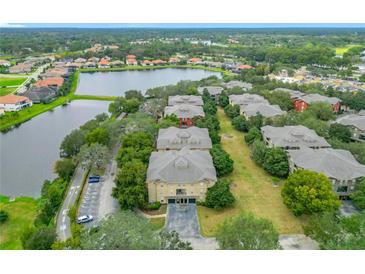 Scenic aerial view of the condominiums in a park-like setting with lush landscaping and a pond at 114 Vista Verdi Cir # 328, Lake Mary, FL 32746