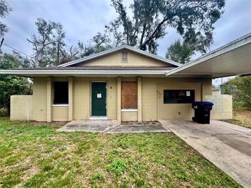 Modest single-story home with a carport and a simple landscaped yard at 115 S Lake Pleasant Rd, Apopka, FL 32703