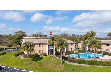 Inviting condo complex with community pool and well-maintained landscaping creates a comfortable living environment at 165 N Pearl Lake Cswy # 202, Altamonte Springs, FL 32714